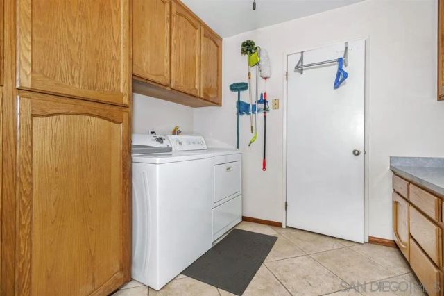 a utility room with cabinets washer and dryer