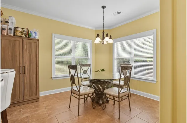 a view of a dining room with furniture and chandelier