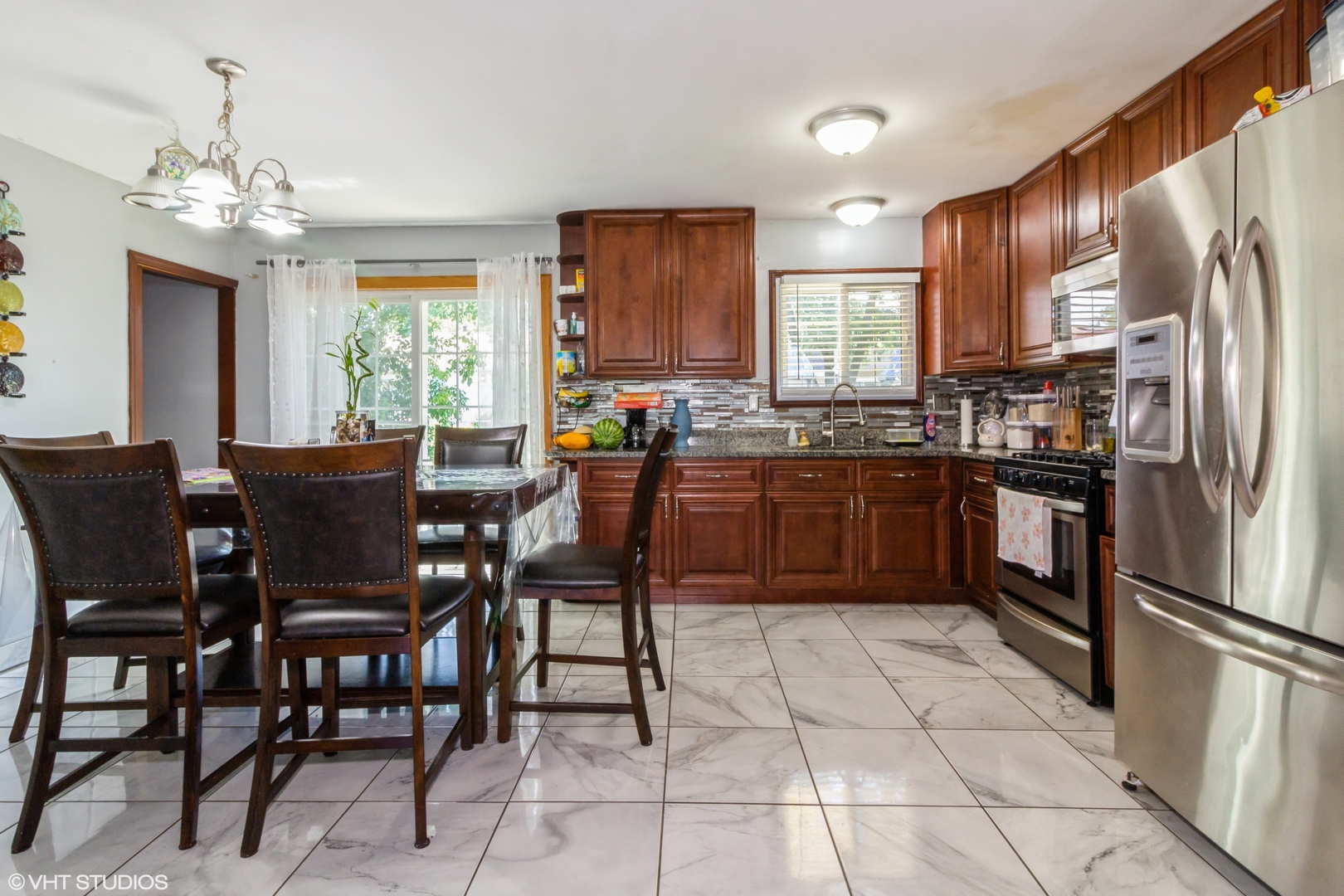 671 Rockhurst Road Bolingbrook, IL 60440 - Photo 5 of 17 a kitchen with stainless steel appliances granite countertop a stove a sink a dining table and chairs