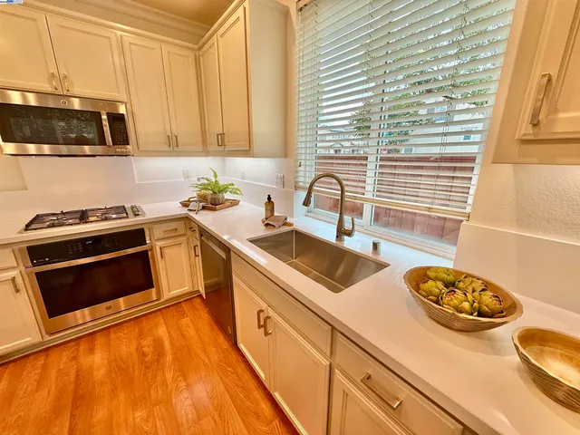 a kitchen with stainless steel appliances a stove a sink and a microwave