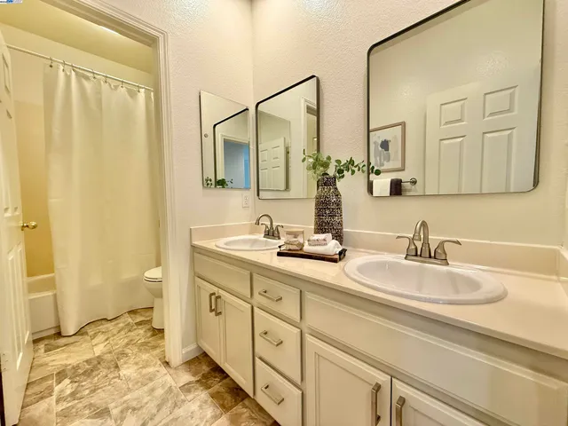 a spacious bathroom with double sink and a mirror