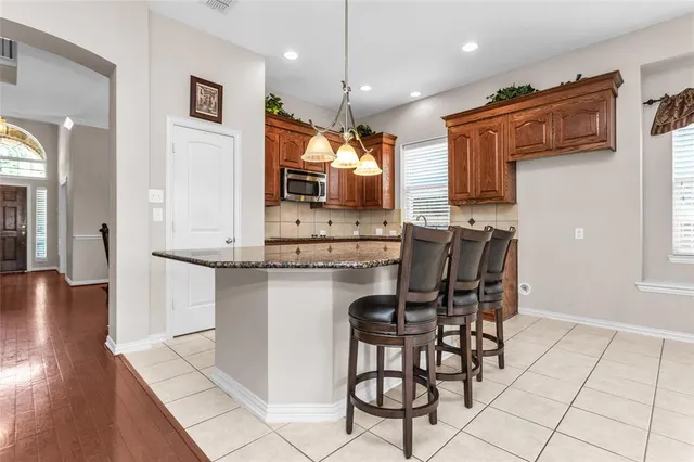 a dining hall with stainless steel appliances a dining table and chairs