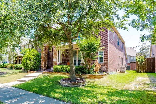 a view of a house with a yard and large tree