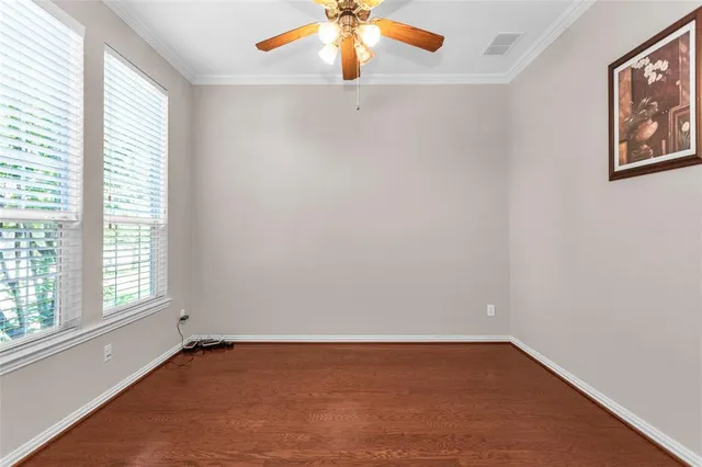 an empty room with window and chandelier fan