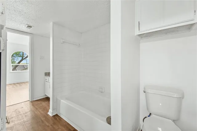 a bathroom with a granite countertop bathtub shower and toilet