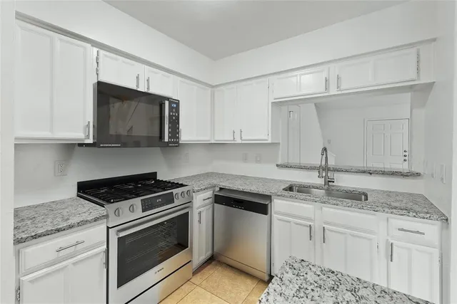 a kitchen with granite countertop white cabinets and white appliances