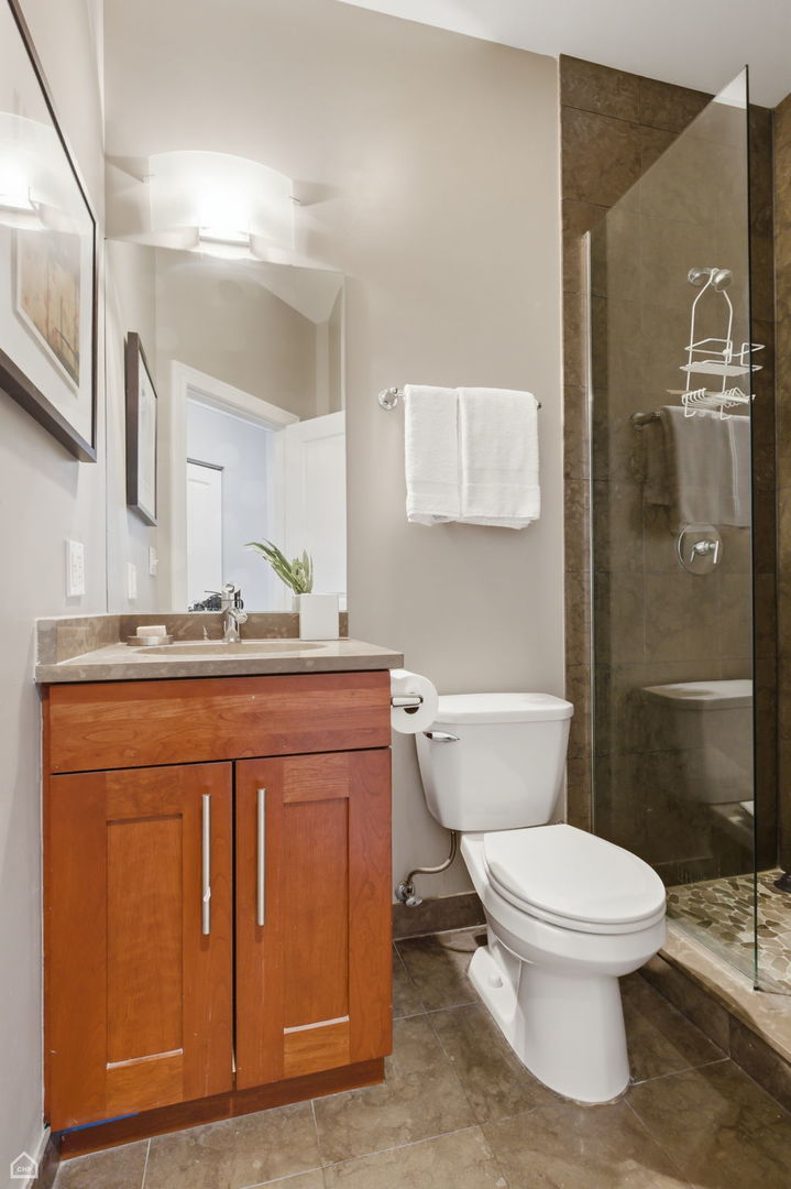 2229 North Leavitt Street, Unit 2 Chicago, IL 60647 - Photo 16 of 19 a bathroom with a granite countertop toilet sink and shower