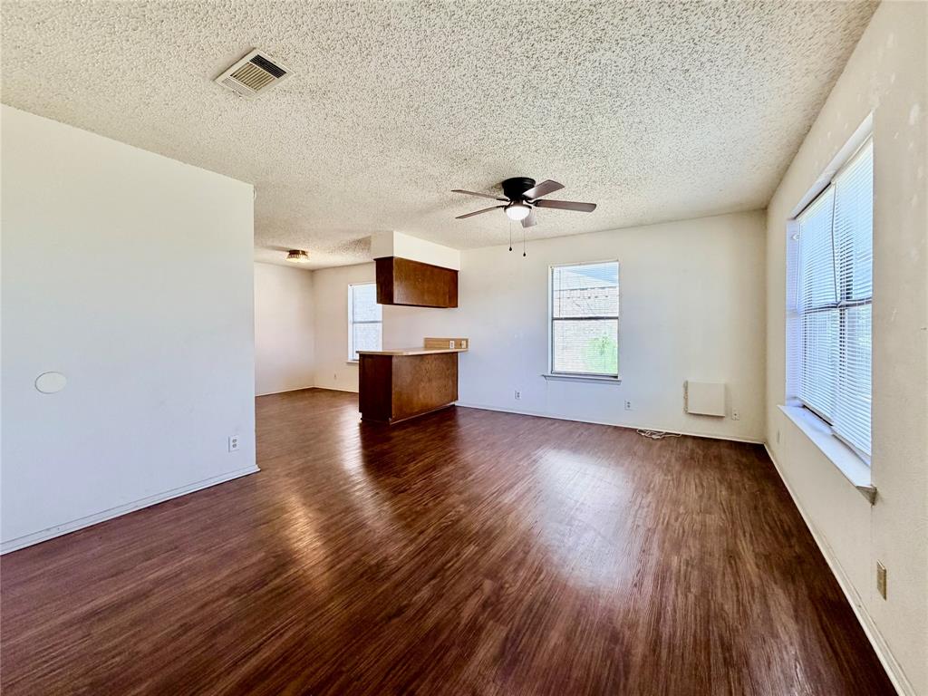 3311 Fallmeadow Street Denton, TX 76207 - Photo 3 of 13 a view of empty room with a kitchen and wooden floor