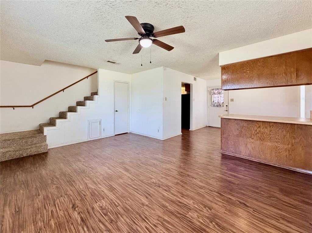 3311 Fallmeadow Street Denton, TX 76207 - Photo 4 of 13 a view of a livingroom with wooden floor and a ceiling fan