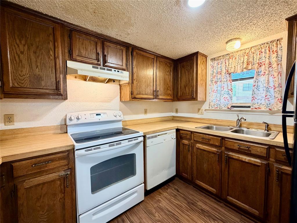 3311 Fallmeadow Street Denton, TX 76207 - Photo 9 of 13 a kitchen with cabinets wooden floor and stainless steel appliances