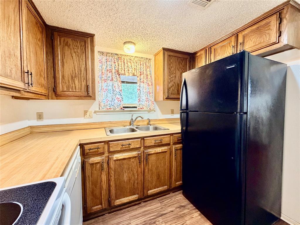 3311 Fallmeadow Street Denton, TX 76207 - Photo 10 of 13 a kitchen with a refrigerator and a sink