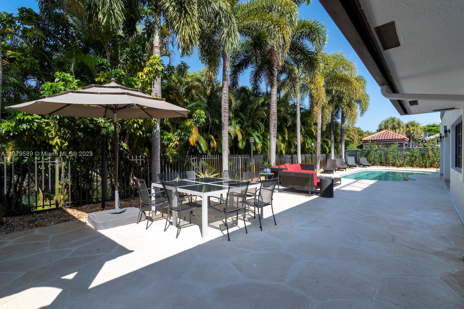 Doral Doral, FL 33178 - Photo 11 of 52 a view of a patio with a table and chairs under an umbrella with a fire pit