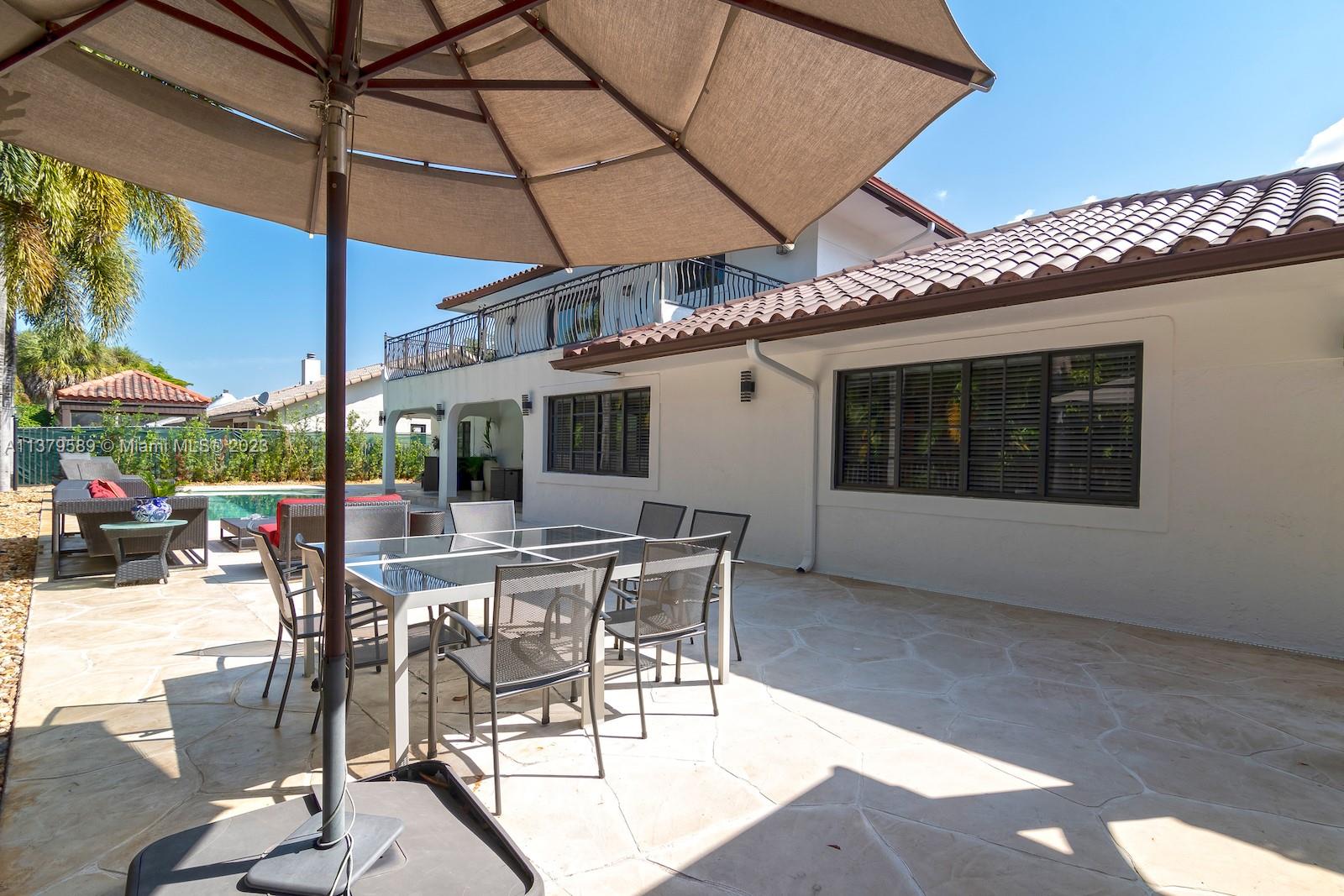 Doral Doral, FL 33178 - Photo 14 of 52 a view of a patio with a table and chairs under an umbrella