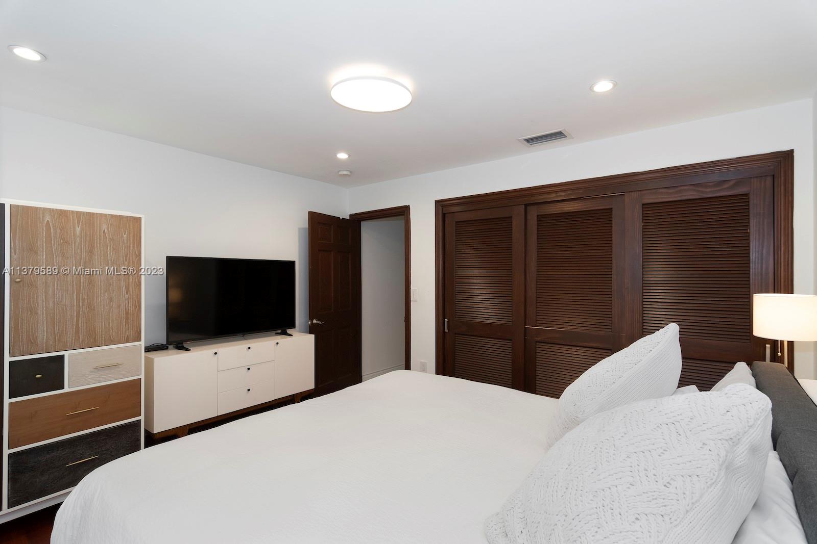 Doral Doral, FL 33178 - Photo 37 of 52 a bedroom with a bed and a flat tv screen tv on the dresser