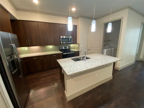 a kitchen with a sink a refrigerator and chairs