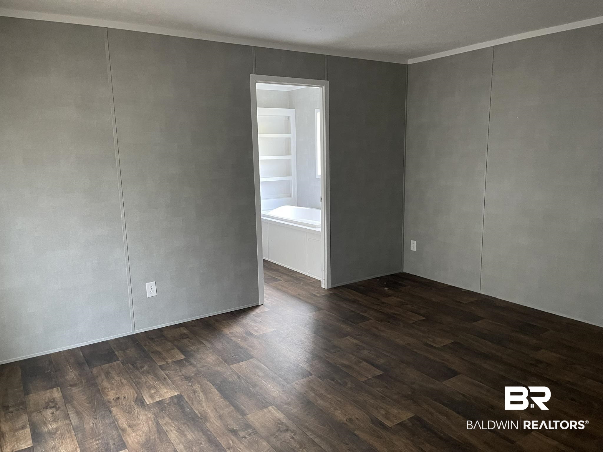 9202 Bay Pnes Road Elberta, AL 36530 - Photo 5 of 17 Unfurnished room with dark wood-style floors, a decorative wall, and crown molding