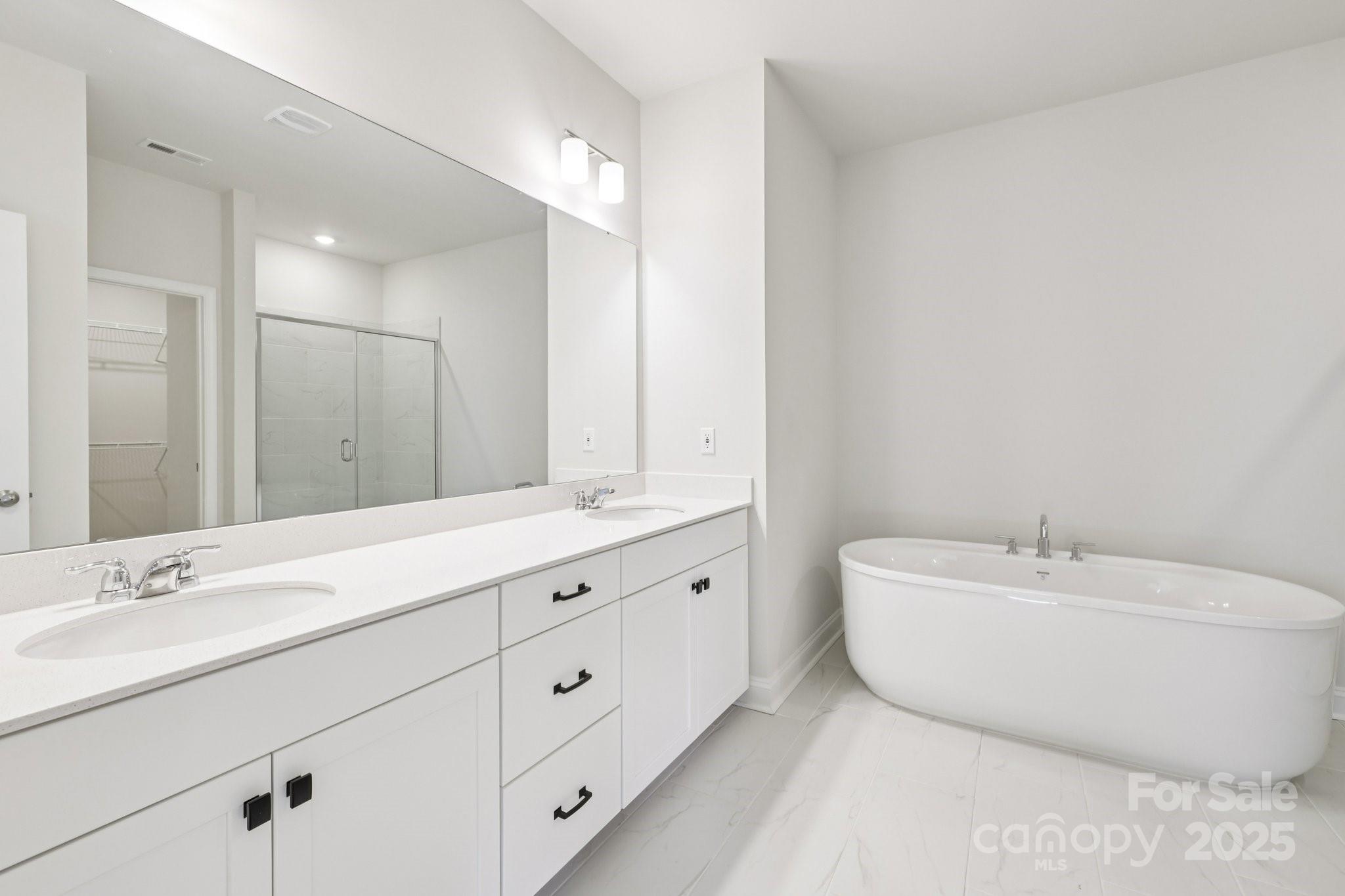 9612 Pointer Road, Unit 59 Huntersville, NC 28078 - Photo 32 of 43 a spacious bathroom with double sink a mirror and a bathtub