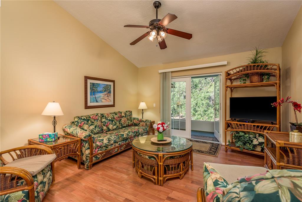 1381 McMullen Booth Road, Unit 1381 Clearwater, FL 33759 - Photo 12 of 36 a living room with furniture a flat screen tv and a large window
