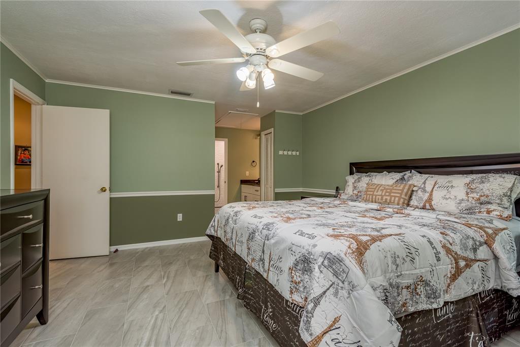 1381 McMullen Booth Road, Unit 1381 Clearwater, FL 33759 - Photo 16 of 36 a bedroom with a large bed and a ceiling fan