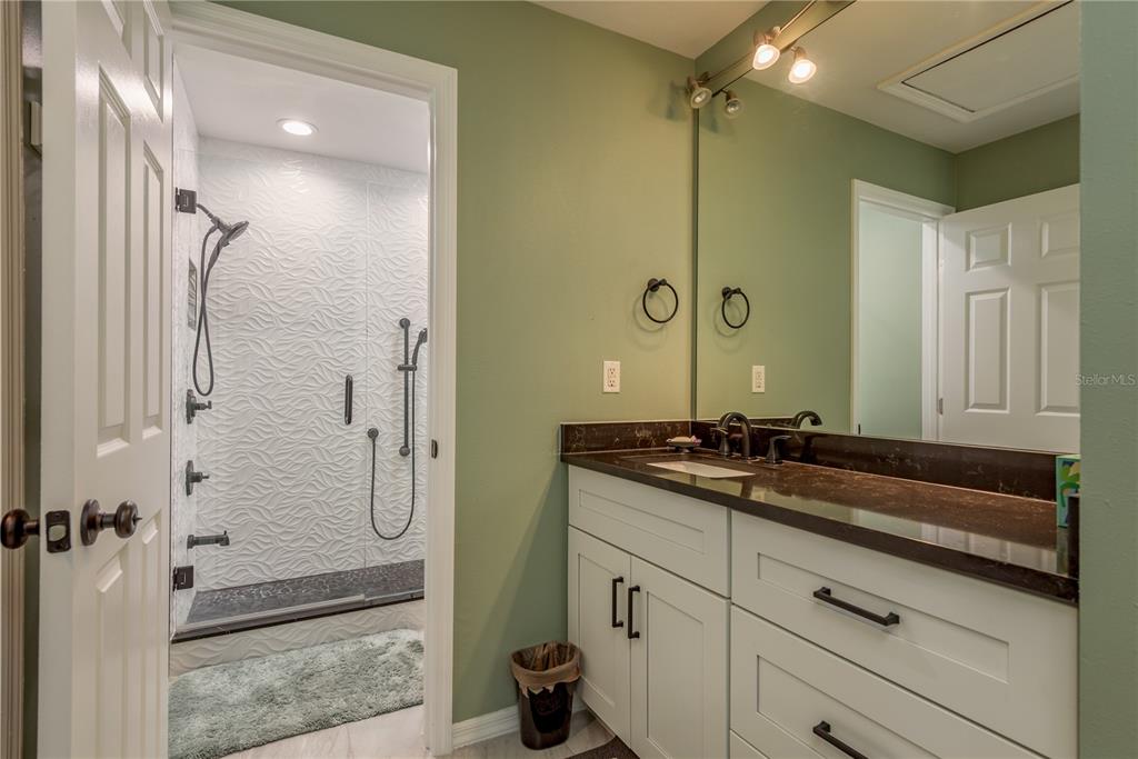 1381 McMullen Booth Road, Unit 1381 Clearwater, FL 33759 - Photo 17 of 36 a spacious bathroom with a granite countertop sink a mirror and shower