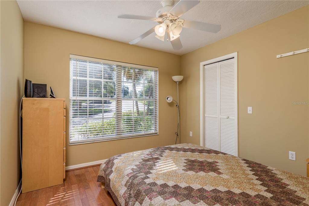 1381 McMullen Booth Road, Unit 1381 Clearwater, FL 33759 - Photo 19 of 36 a view of a bedroom with a bed and a chandelier