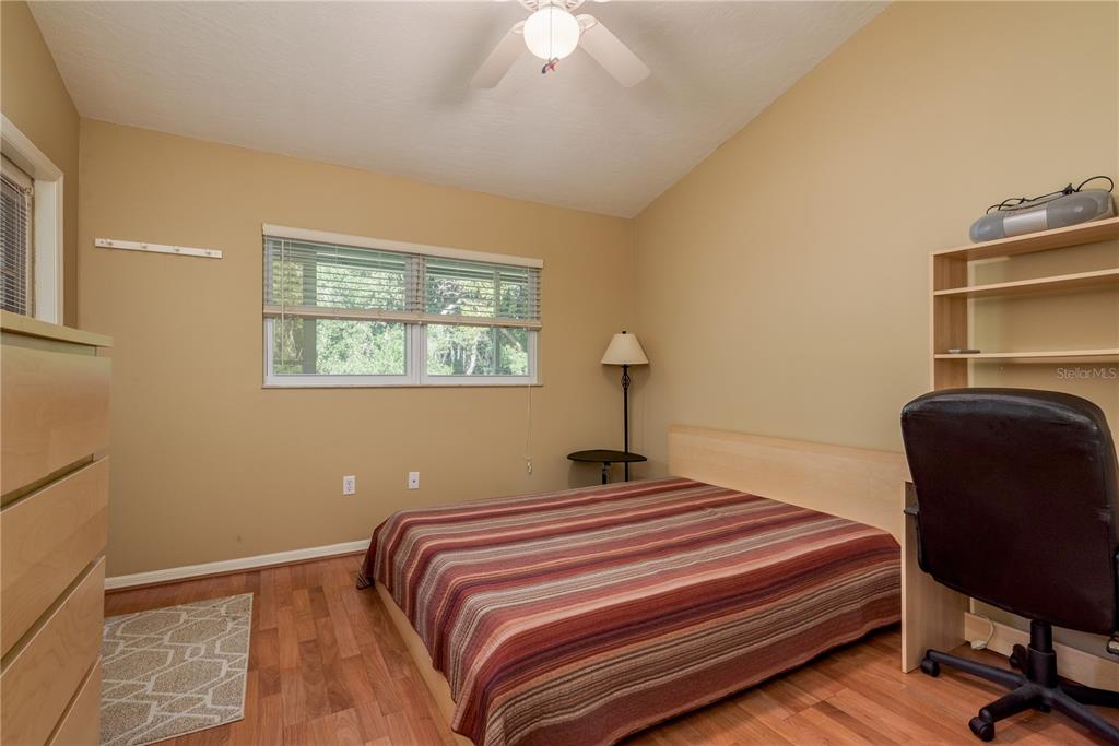 1381 McMullen Booth Road, Unit 1381 Clearwater, FL 33759 - Photo 22 of 36 a bedroom with a bed and chair