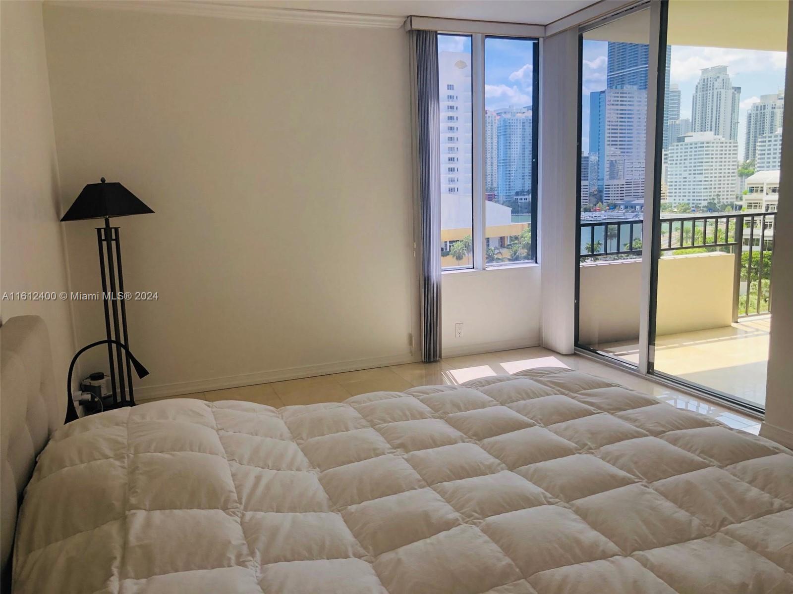 520 Brickell Key Drive, Unit A1005 Miami, FL 33131 - Photo 11 of 20 a bedroom with a bed and a lamp