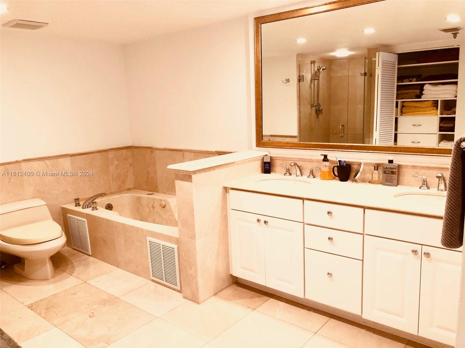 520 Brickell Key Drive, Unit A1005 Miami, FL 33131 - Photo 12 of 20 a bathroom with a toilet a sink a mirror and a bathtub