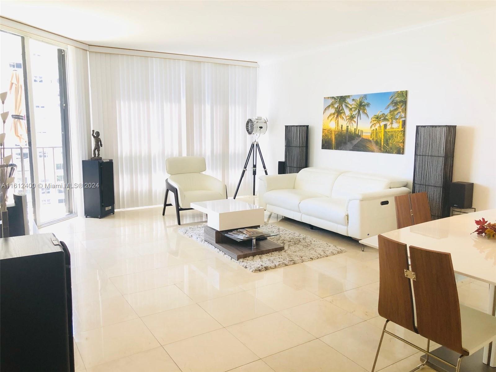 520 Brickell Key Drive, Unit A1005 Miami, FL 33131 - Photo 3 of 20 a living room with furniture a large window and a flat screen tv