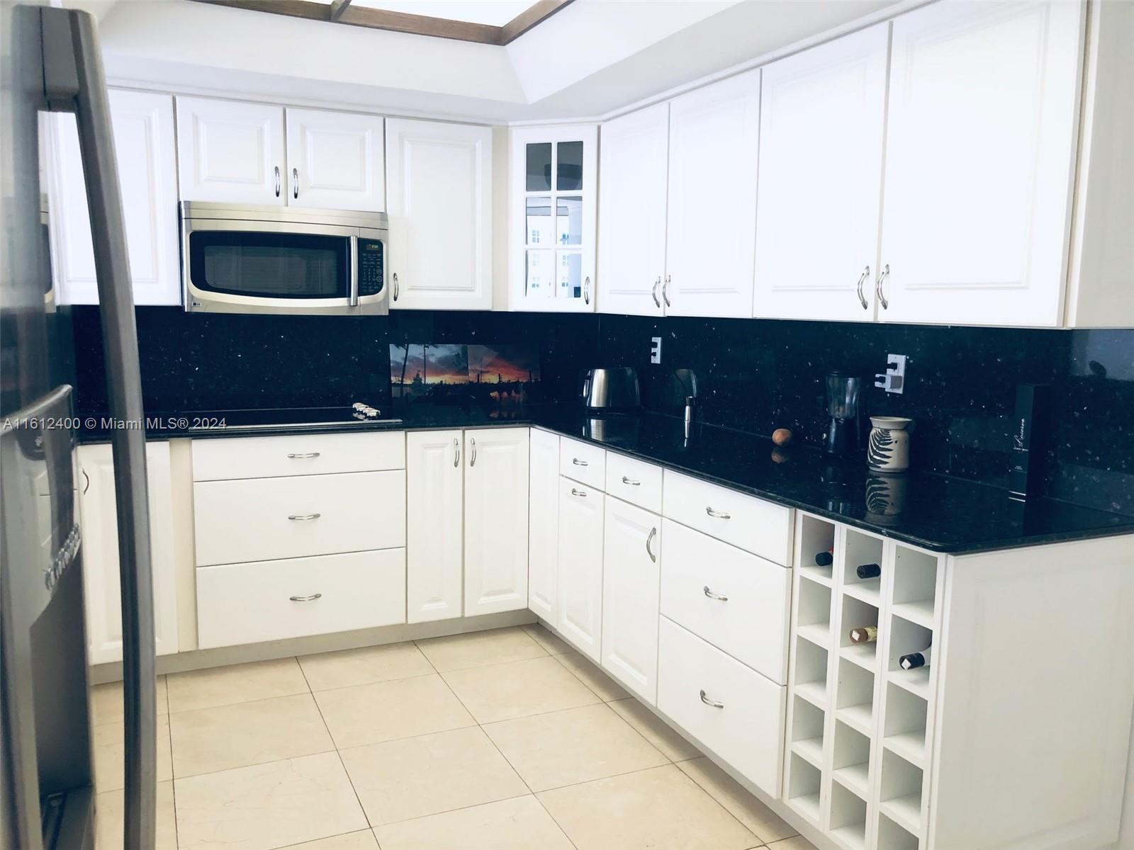 520 Brickell Key Drive, Unit A1005 Miami, FL 33131 - Photo 9 of 20 a kitchen with a sink and a cabinets