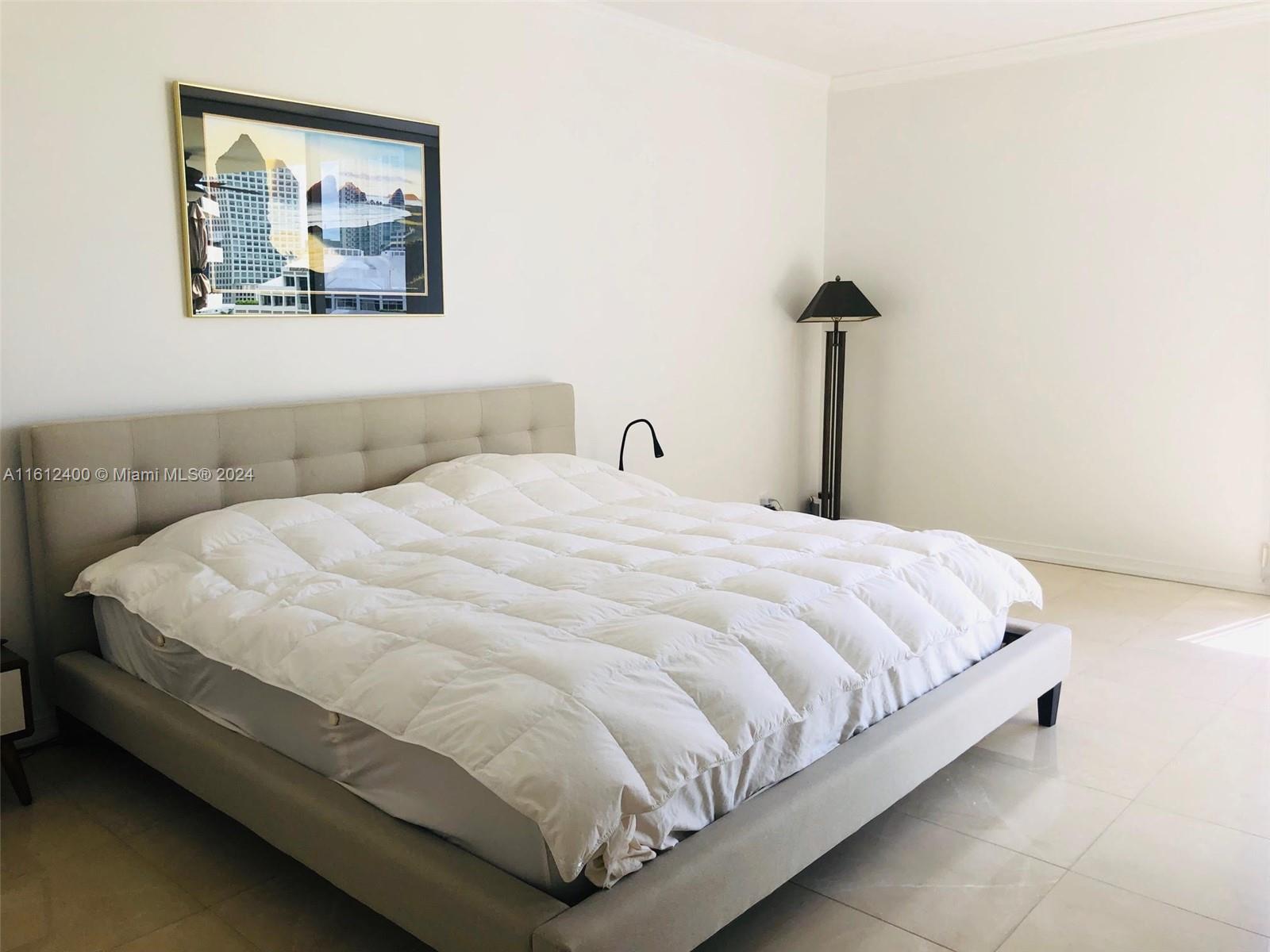 520 Brickell Key Drive, Unit A1005 Miami, FL 33131 - Photo 10 of 20 a large bed sitting in a bedroom next to a wall