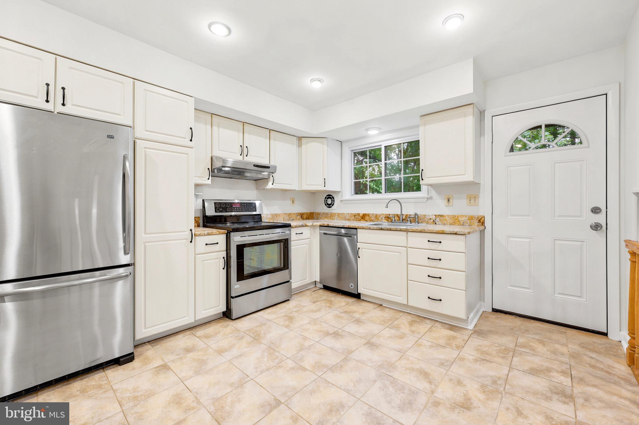 412 Yorkshire Road Bryn Mawr, PA 19010 - Photo 10 of 25 a kitchen with white cabinets and stainless steel appliances