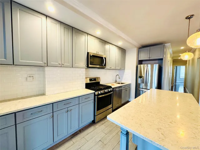 a kitchen with stainless steel appliances granite countertop a sink a stove and a wooden floors