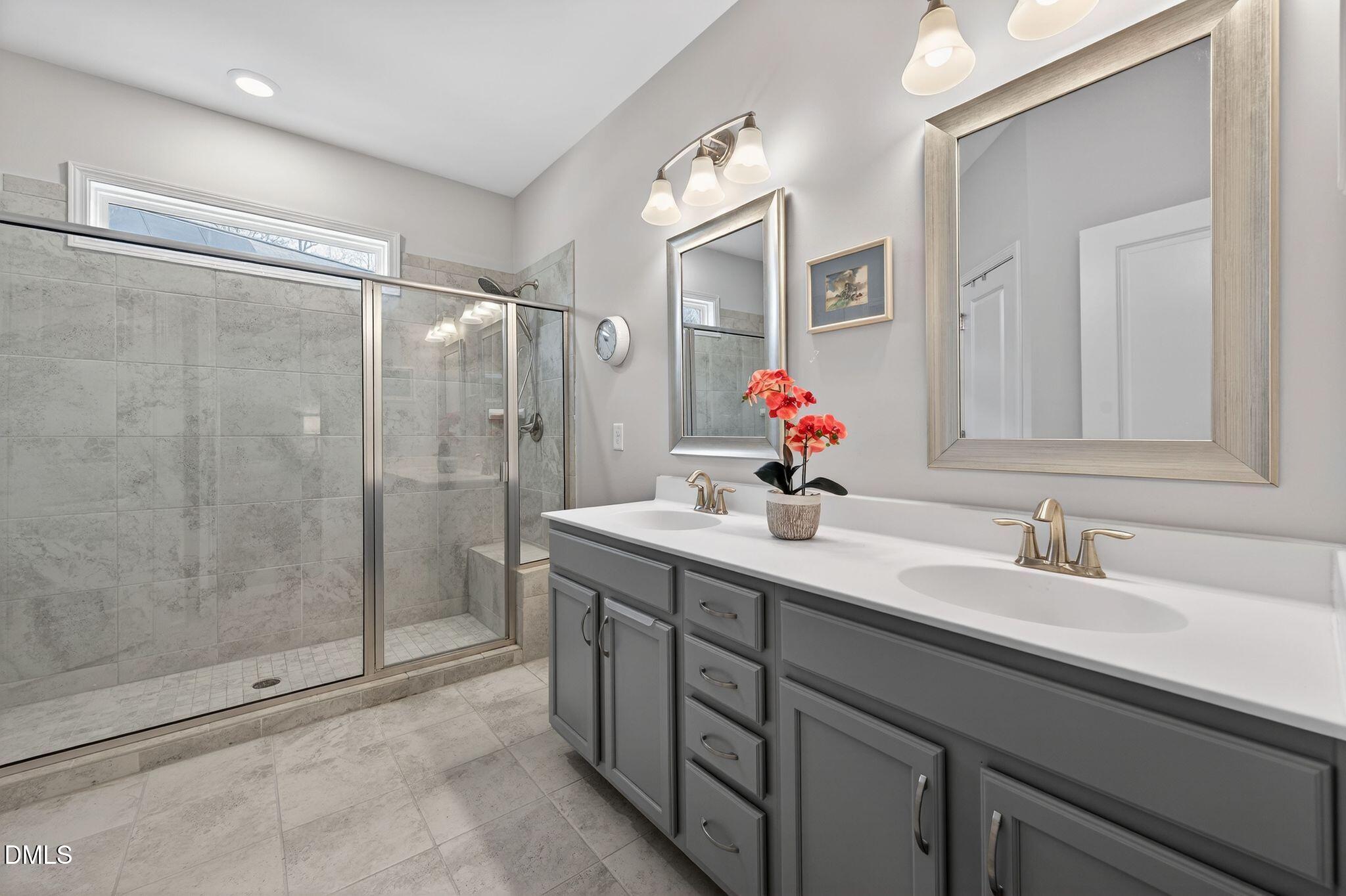 528 Spring Flower Court Cary, NC 27511 - Photo 25 of 51 a bathroom with a shower sink and mirror