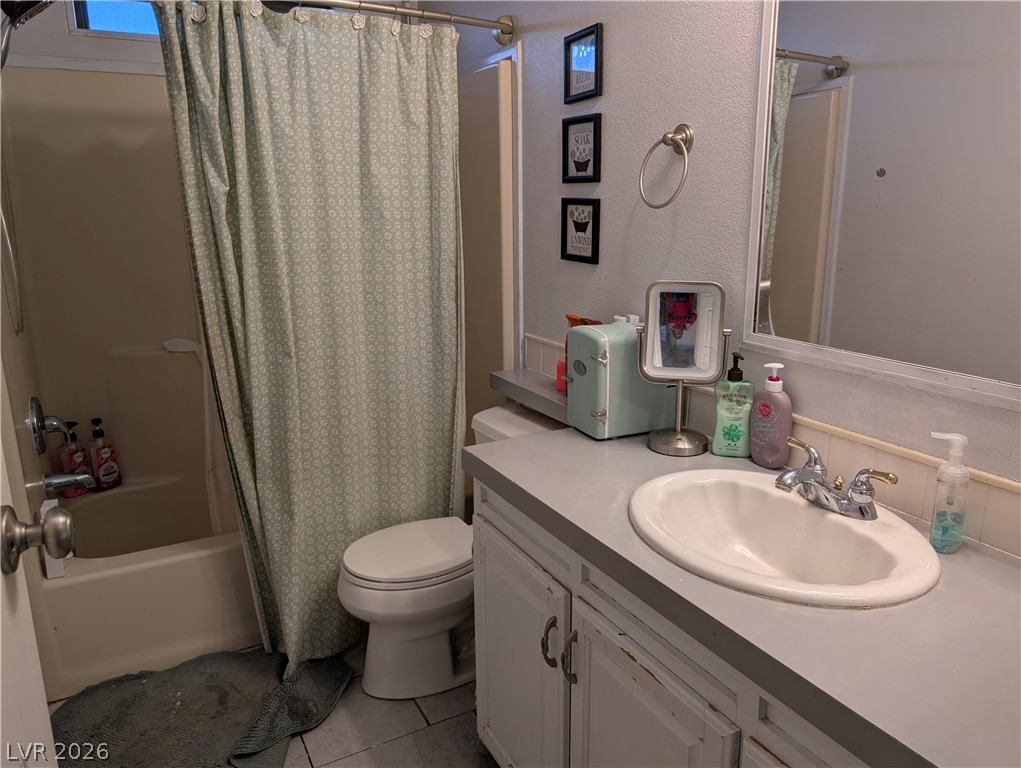 320 6th Street Panaca, NV 89042 - Photo 23 of 31 Bathroom featuring vanity, shower / bathtub combination with curtain, a textured wall, and light tile patterned floors