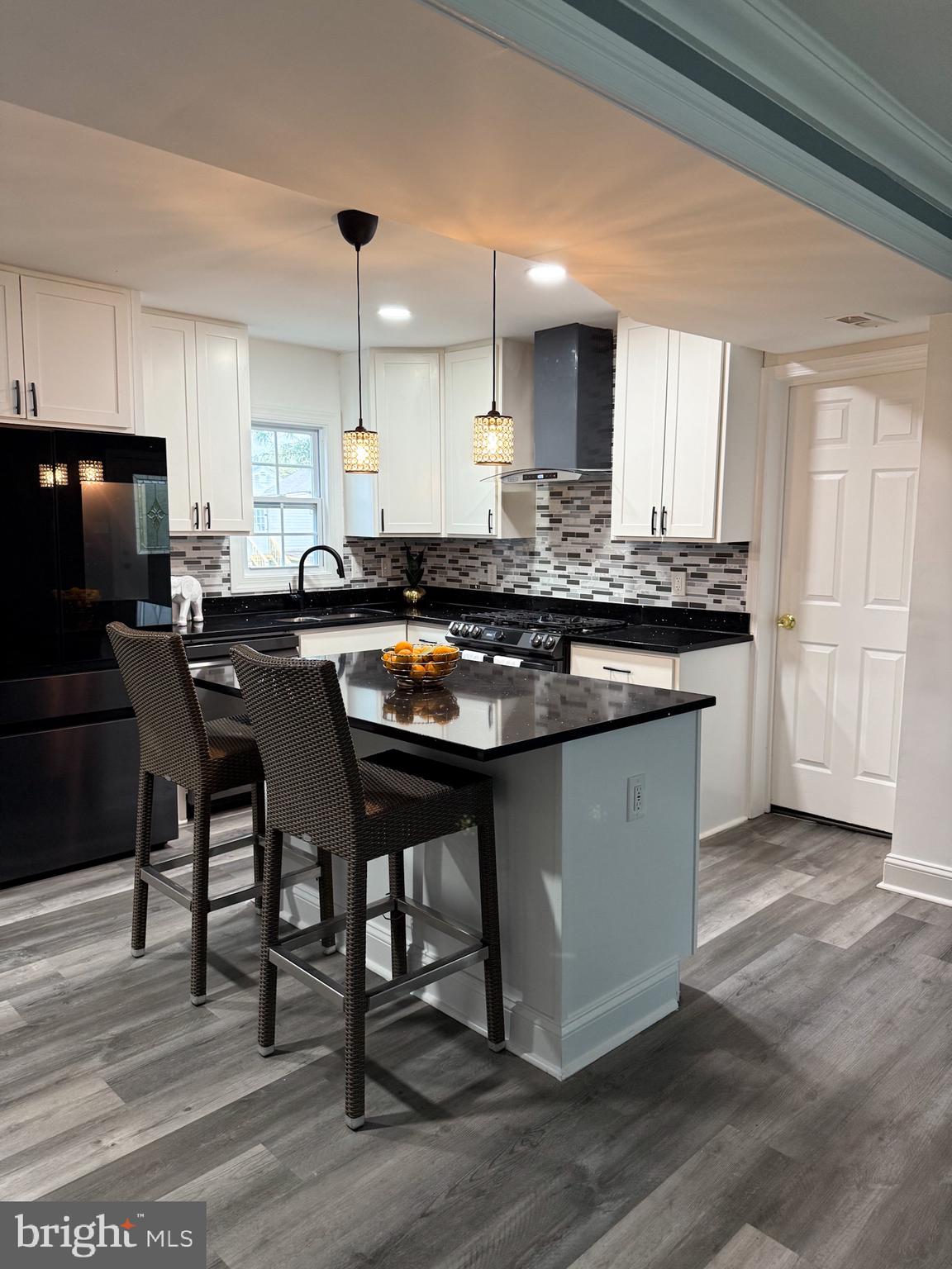 1803 Amherst Road Hyattsville, MD 20783 - Photo 3 of 17 a kitchen with a stove a sink a refrigerator and chairs