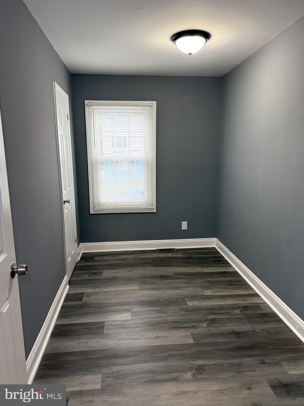 1803 Amherst Road Hyattsville, MD 20783 - Photo 10 of 17 a view of an empty room with wooden floor and a window