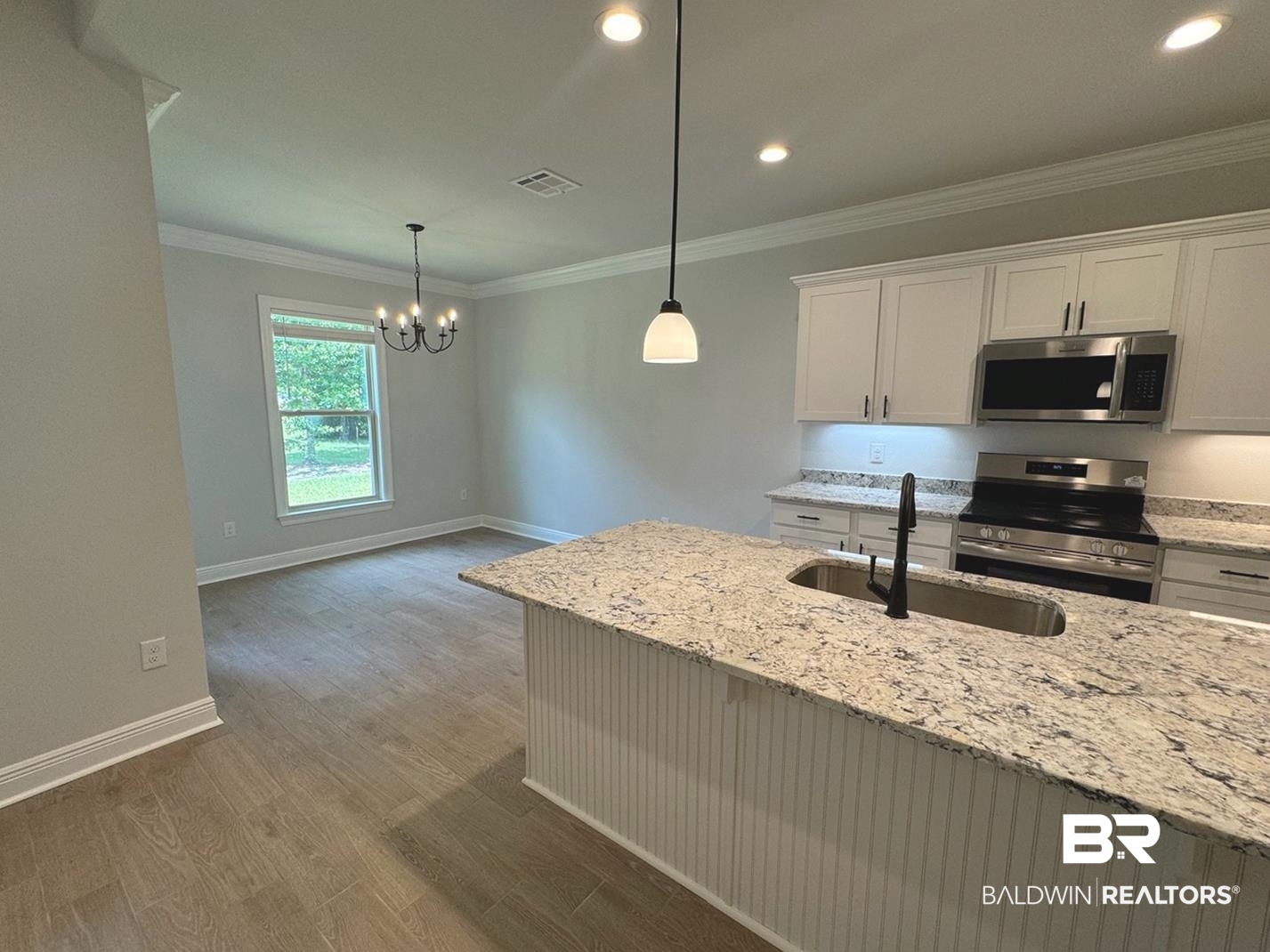 860 Sumter Loop Foley, AL 36535 - Photo 10 of 26 Kitchen with stainless steel appliances, light stone countertops, ornamental molding, and dark wood-type flooring