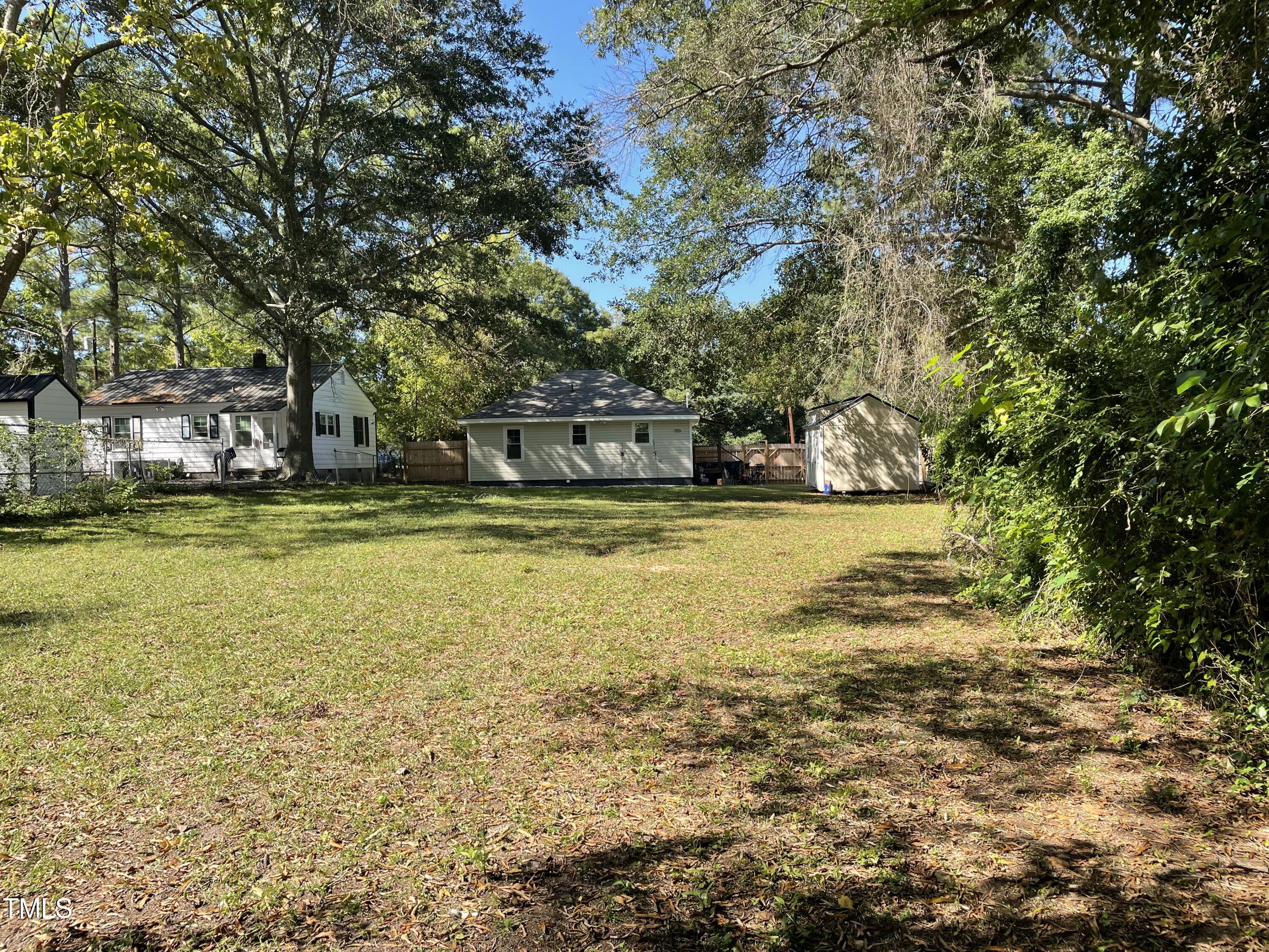 204 Jackson Street Dunn, NC 28334 - Photo 18 of 49 a view of a large pool with lawn chairs under an umbrella