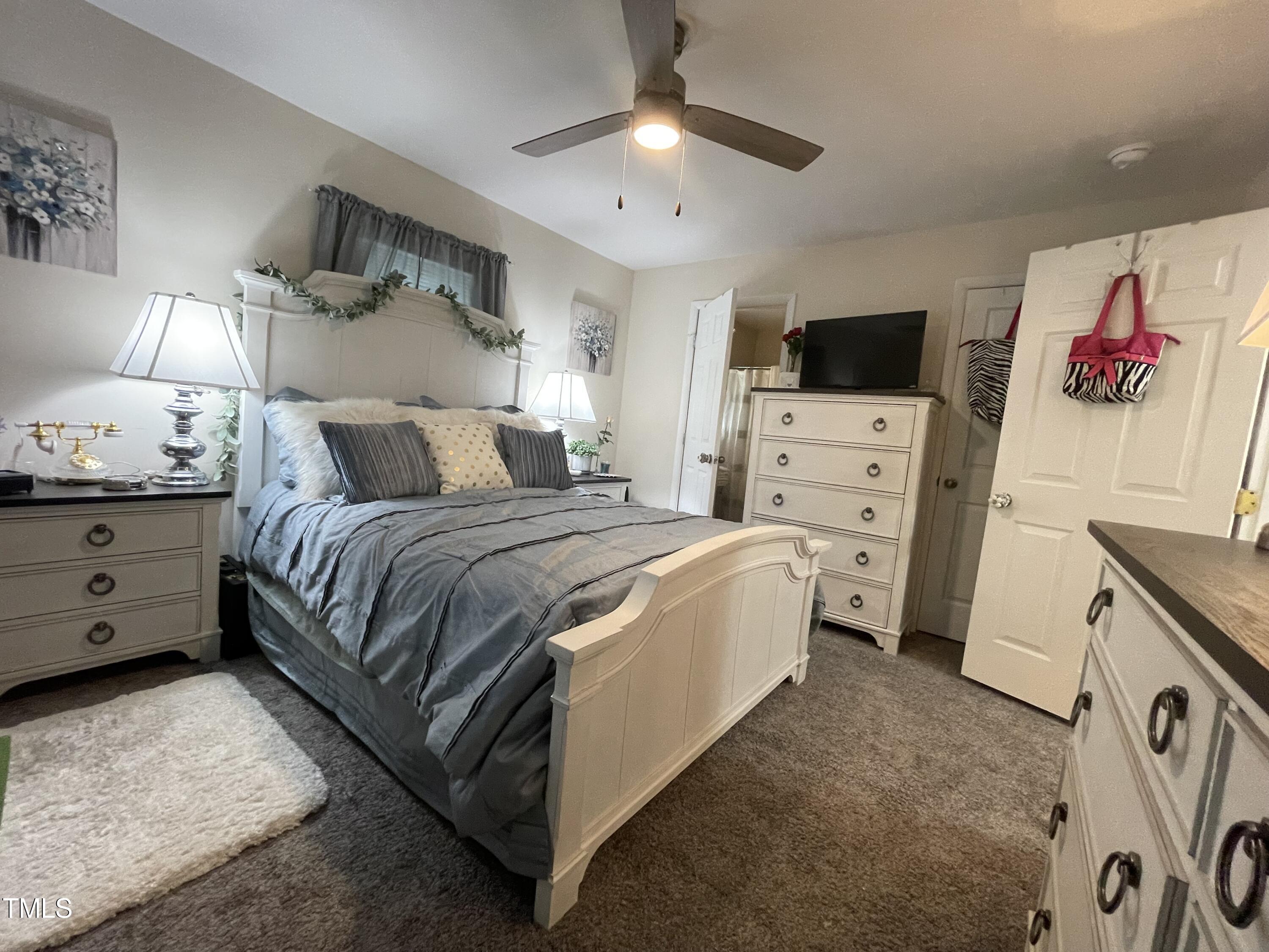204 Jackson Street Dunn, NC 28334 - Photo 27 of 49 a spacious bedroom with a bed and a flat screen tv