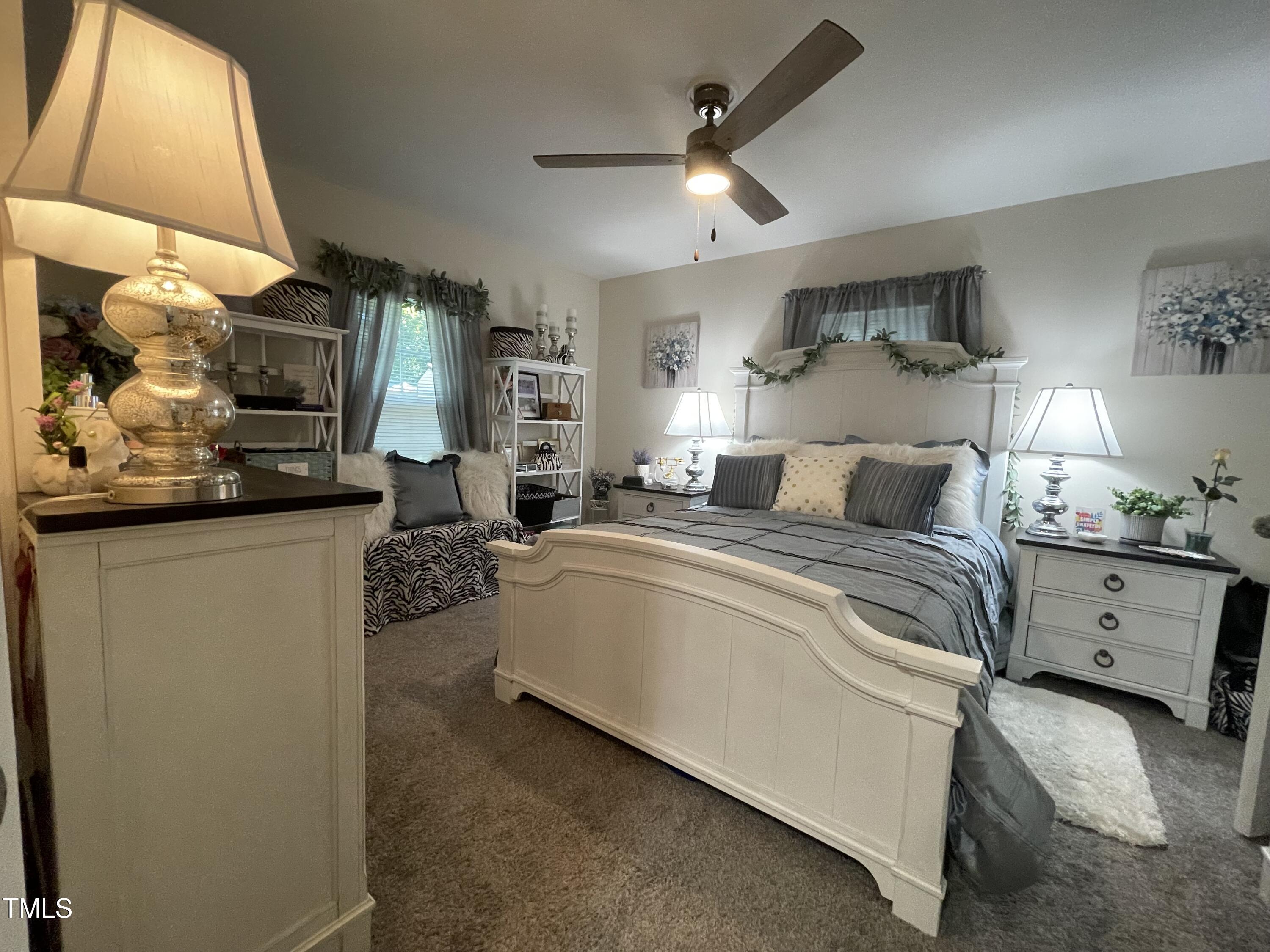 204 Jackson Street Dunn, NC 28334 - Photo 29 of 49 a bedroom with a large bed and a chandelier