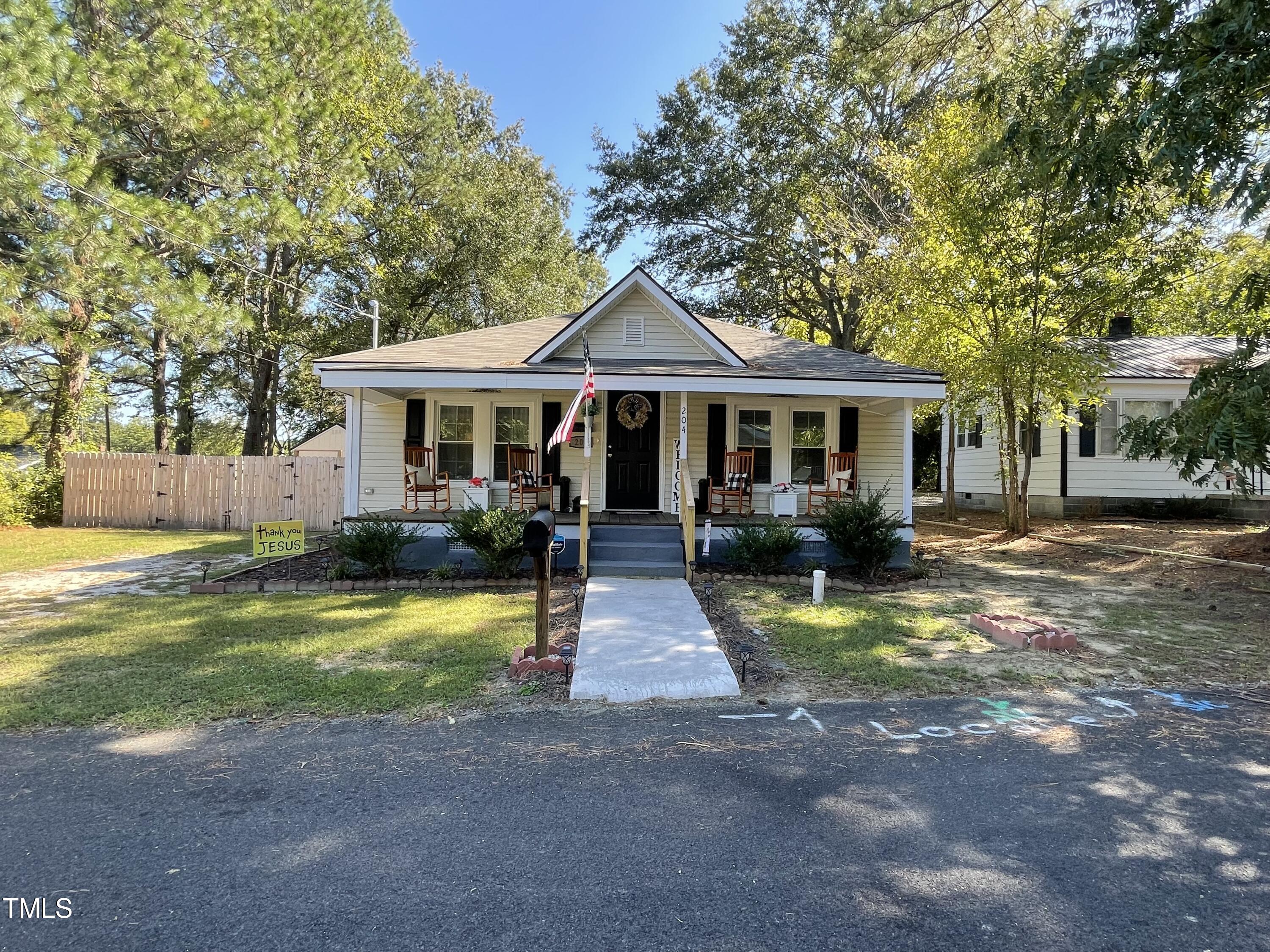 204 Jackson Street Dunn, NC 28334 - Photo 3 of 49 a front view of a house with a yard table and chairs