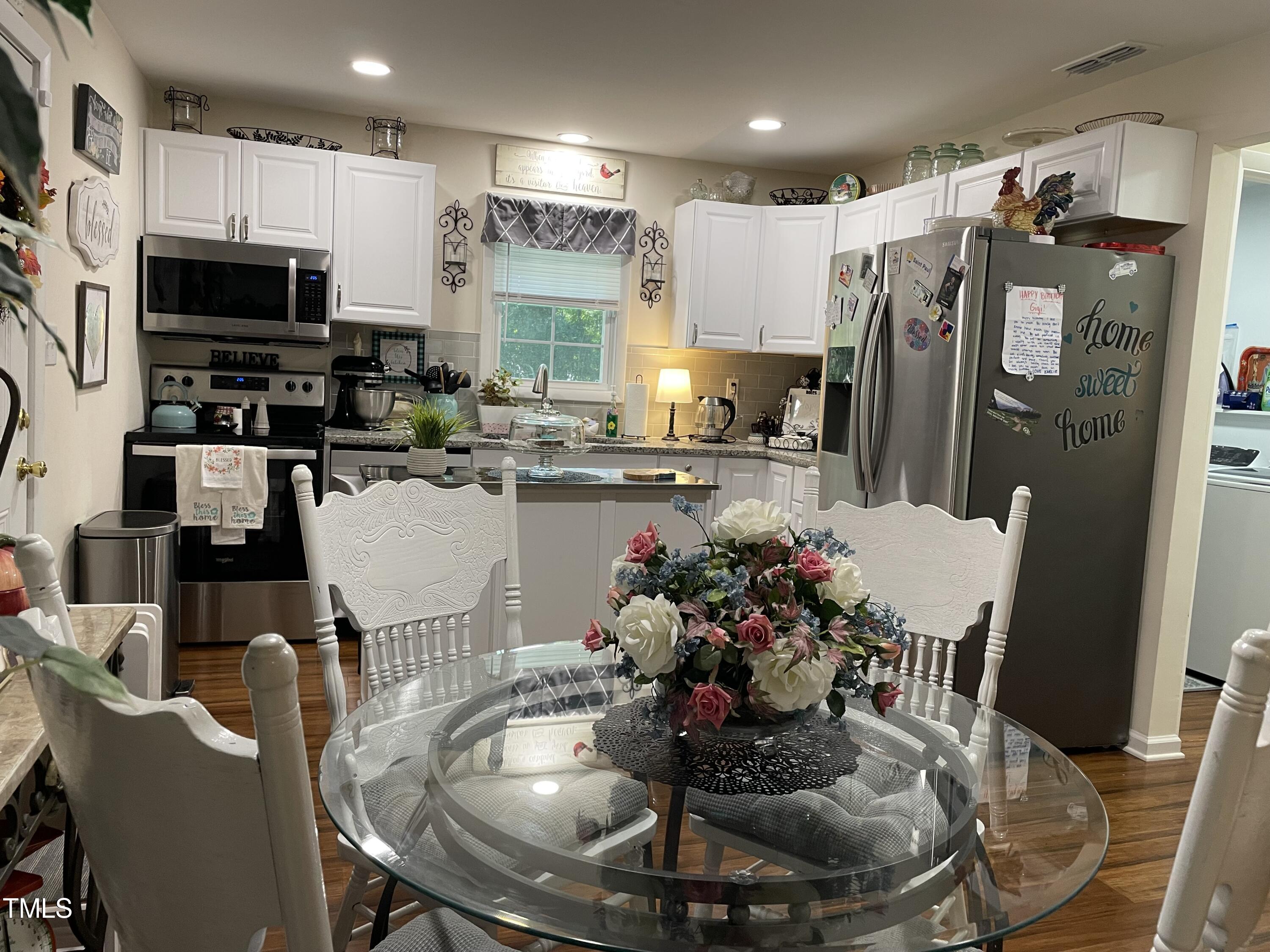 204 Jackson Street Dunn, NC 28334 - Photo 38 of 49 a kitchen with stainless steel appliances granite countertop a dining table chairs and a refrigerator