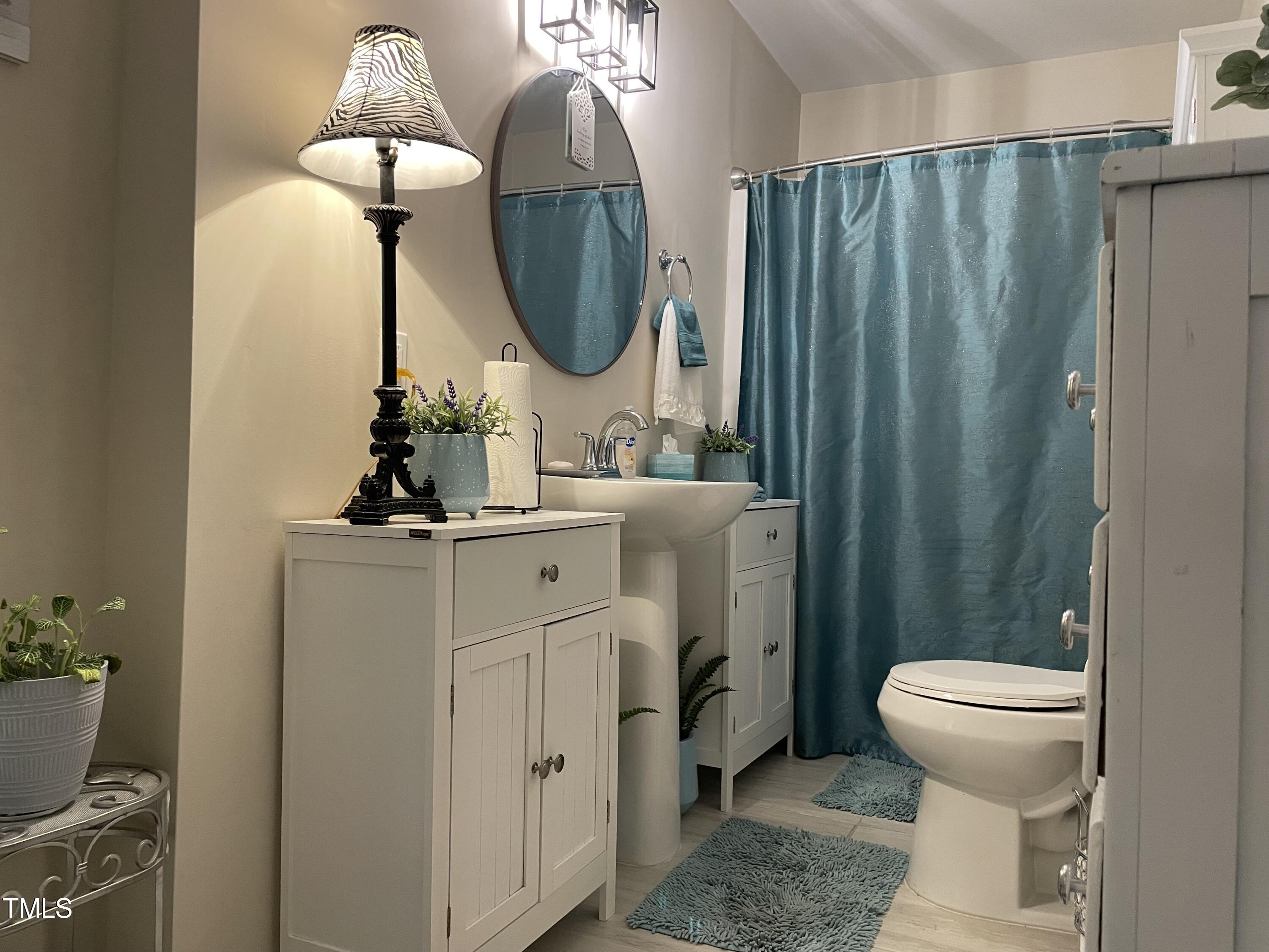204 Jackson Street Dunn, NC 28334 - Photo 45 of 49 a bathroom with a toilet sink and mirror
