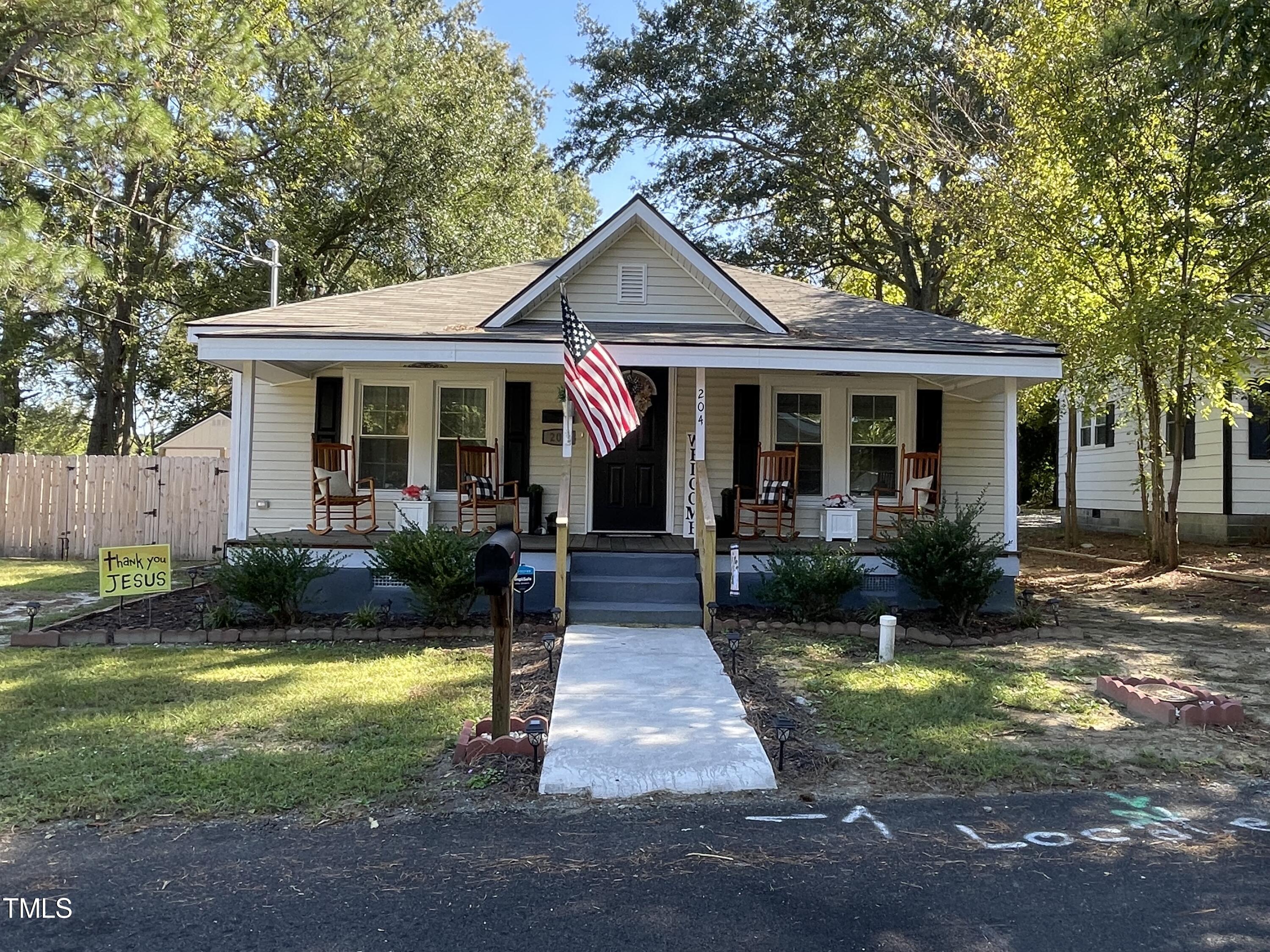 204 Jackson Street Dunn, NC 28334 - Photo 6 of 49 a front view of a house with garden and patio