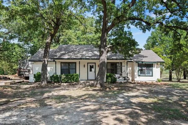 a front view of a house with yard patio and green space