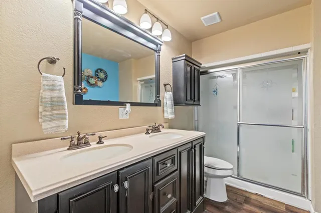 a bathroom with a sink vanity granite toilet and a mirror