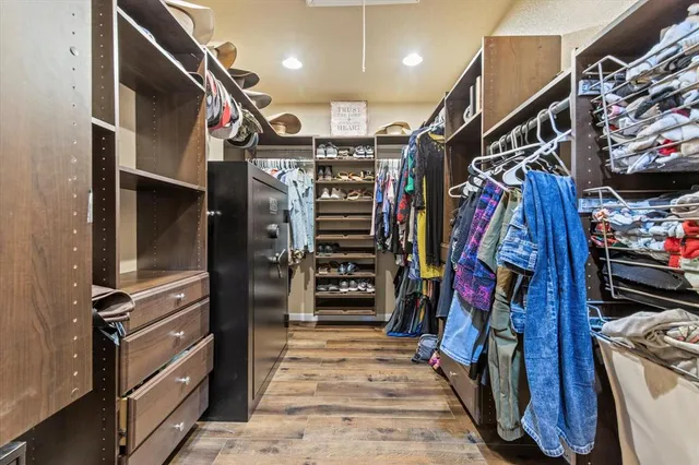a view of walk in closet with clothes and shoes