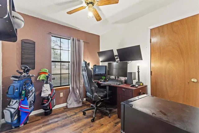 a view of a workspace with furniture and a window