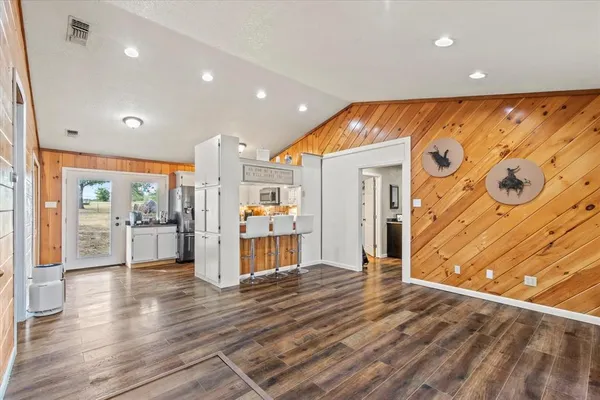 a view of a big room with wooden floor and windows